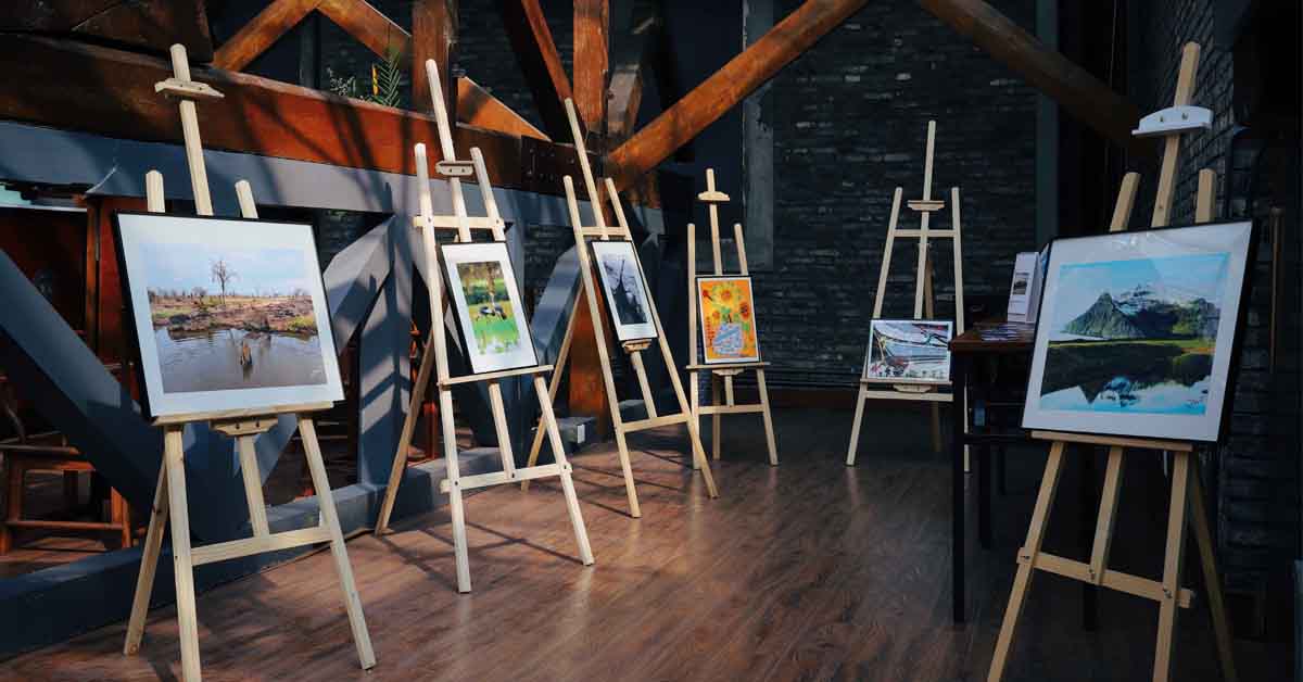 A room with 6 easels holding paintings