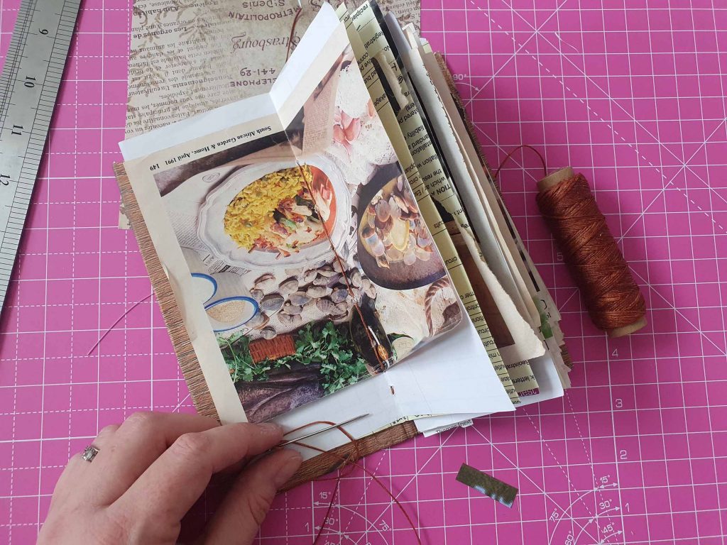 A hand sewing spine and signatures of a junk journal