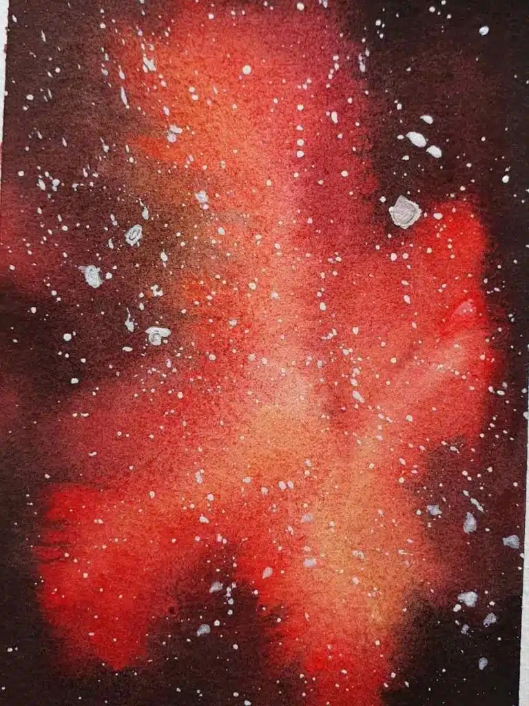 red galaxy watercolor painting with white flecks of paint